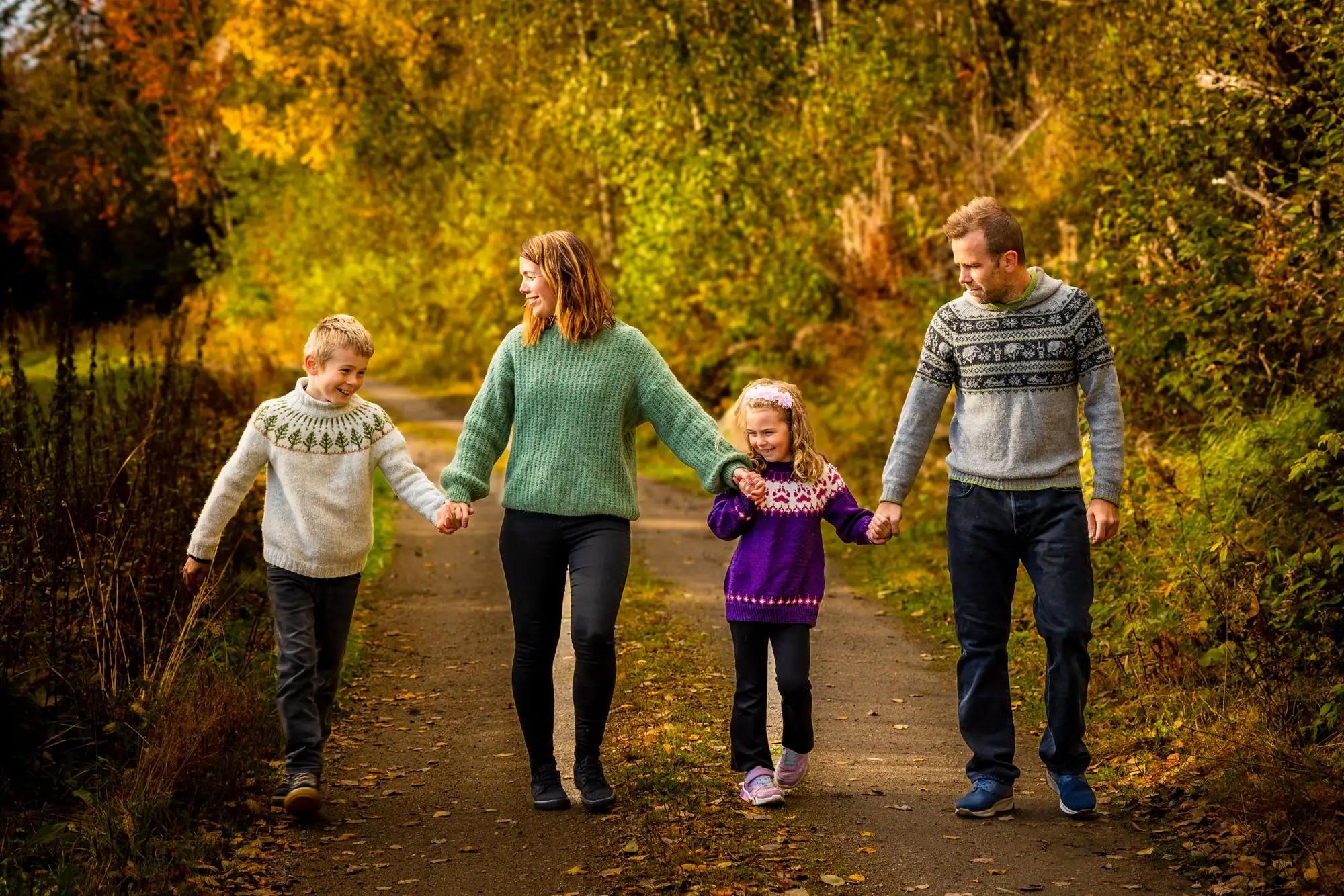 Familie i varmt høstlys blant trærne, fotografert av Marte Bjørgum