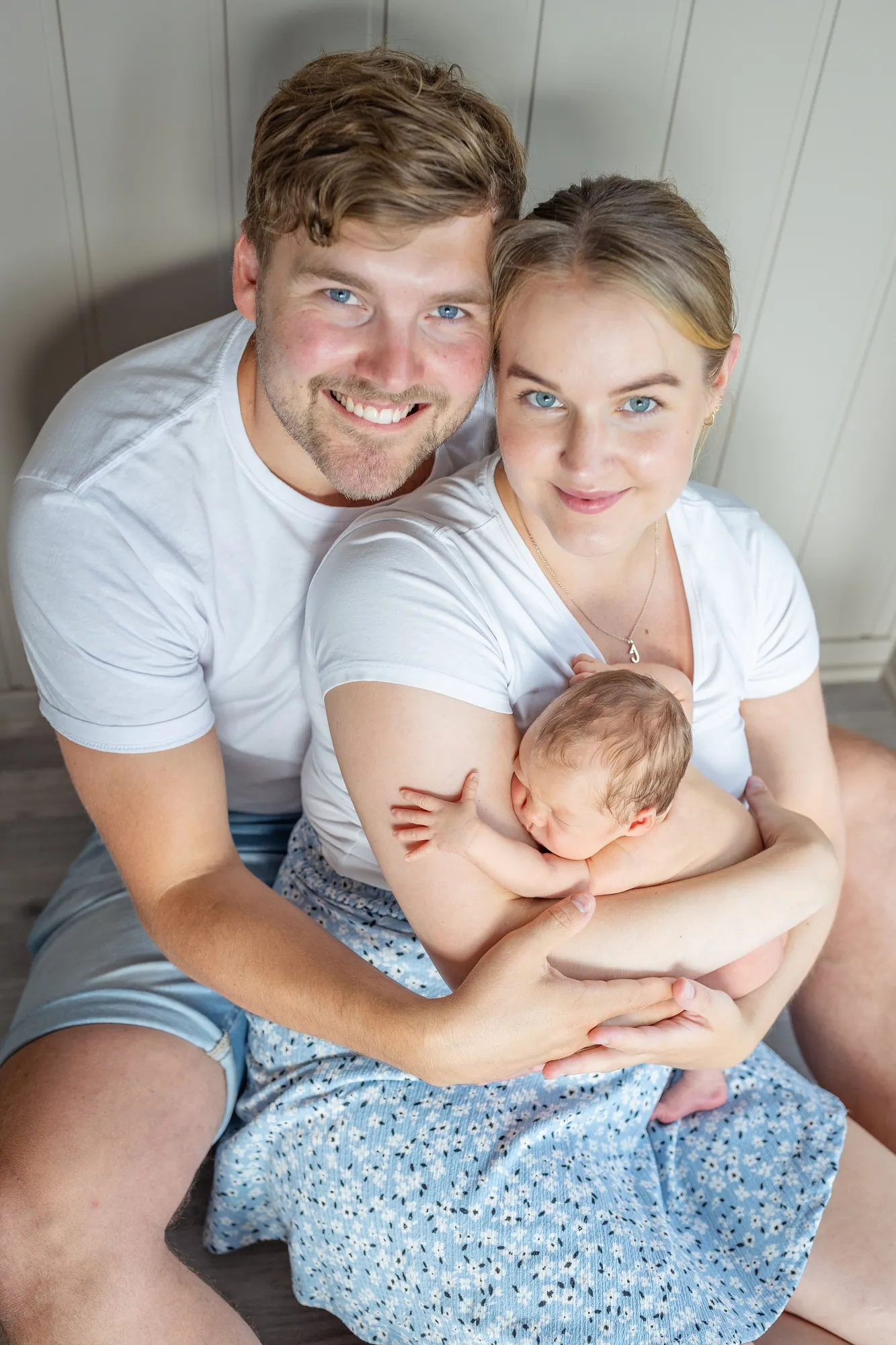 Nybakte foreldre med den nyfødte i fanget, fotografert av Marte Bjørgum
